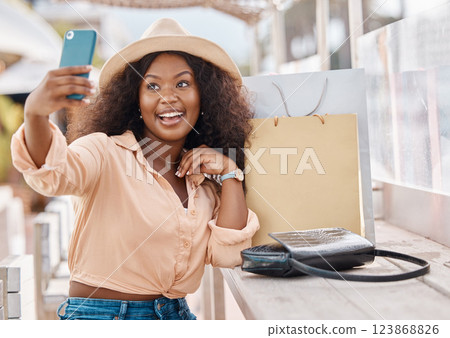 Selfie, shopping bags and woman with phone, happy in hat at city cafe. At the mall, girl with smile and smartphone on 5g video call after discount sale at luxury fashion retail shop on summer holiday Selfie, shopping bags and woman with phone, happy in hat at city cafe. At the mall, girl with smile and smartphone on 5g video call after discount sale at luxury fashion retail shop on summer holiday 123868826