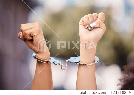 Activist woman hands fist, handcuffs and social justice protest of women protesting outdoor. Hand view of empowerment, black lives matter or iran sexual assault fight for human rights with power 123868869