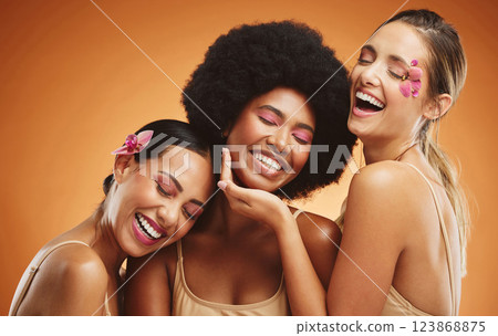 Beauty, skincare and model women in studio with flowers, makeup and cosmetics by brown background. Diversity, happiness and friends with natural self care, cosmetology and face treatment with floral. 123868875