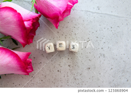 Answer - yes. Exclamation word on the stone table background with pink flowers. Answer - yes. Exclamation word on the stone table background with pink flowers. 123868904