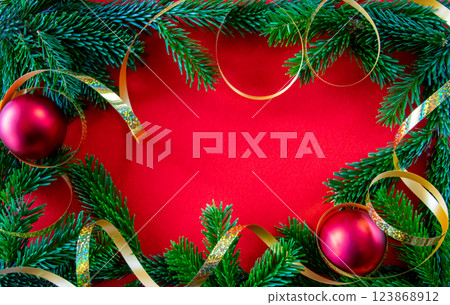 Red bright Christmas background. Green branch, gold tape on the textured fabric background. Copy space. Top view.  123868912