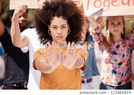 Protest, hands and stop with a black woman activist in demonstration with a group of people ready to fight for freedom. Community, politics and rally with a young female standing against violence 123868924