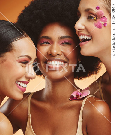 Women, beauty and flowers, makeup and diversity of models on orange studio background. Skincare, face and happy, young and elegant female group posing together with cosmetics, orchids or pink plants. Women, beauty and flowers, makeup and diversity of models on orange studio background. Skincare, face and happy, young and elegant female group posing together with cosmetics, orchids or pink plants. 123868949