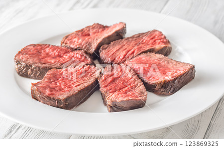 Perfectly sliced medium-rare fillet mignon steak served on a white plate 123869325