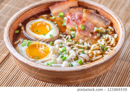 Hearty rustic ramen bowl with pork belly, beech mushrooms, and ramen eggs Hearty rustic ramen bowl with pork belly, beech mushrooms, and ramen eggs 123869339
