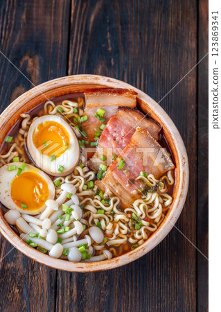 Hearty rustic ramen bowl with pork belly, beech mushrooms, and ramen eggs 123869341