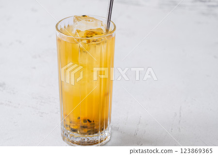 Passion Fruit Caipirinha cocktail in highball glass with straw on white wooden Passion Fruit Caipirinha cocktail in highball glass with straw on white wooden 123869365