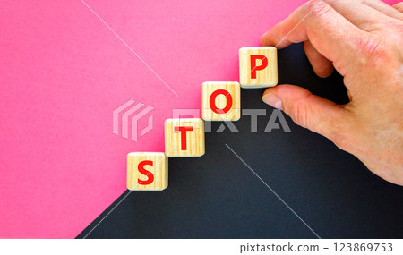 Stop symbol. Concept word Stop on beautiful wooden blocks. Businessman hand. Beautiful black and purple background. Business, lifestyle, support and stop concept. Copy space. Stop symbol. Concept word Stop on beautiful wooden blocks. Businessman hand. Beautiful black and purple background. Business, lifestyle, support and stop concept. Copy space. 123869753