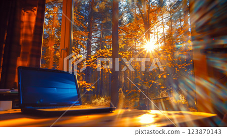 Window in the country house looking at autumn forest. Open laptop computer is on the desk 123870143