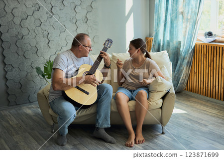 Grandfather and granddaughter sing and play guitar Grandfather and granddaughter sing and play guitar 123871699