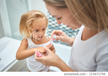 Young mother and daughter in curlers in a bathroom 123871798