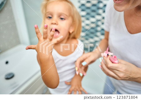 Young mother and daughter in curlers in a bathroom 123871804