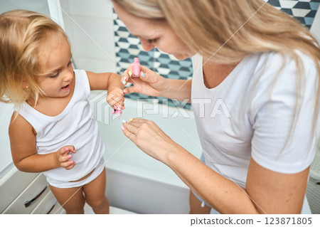 Young mother and daughter in curlers in a bathroom 123871805