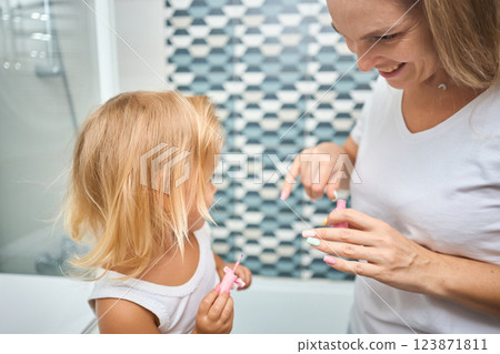 Young mother and daughter in curlers in a bathroom Young mother and daughter in curlers in a bathroom 123871811