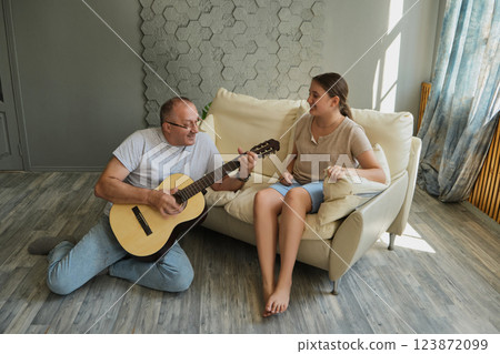 Grandfather and granddaughter sing and play guitar Grandfather and granddaughter sing and play guitar 123872099