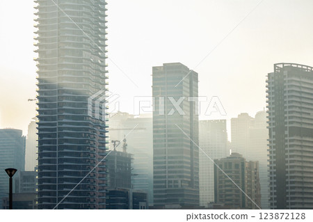 Smog fog in the city from car exhaust gases, multi-story buildings in a light haze Smog fog in the city from car exhaust gases, multi-story buildings in a light haze 123872128