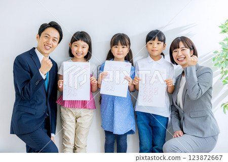 A child and his teacher holding an exam paper with 100 points A child and his teacher holding an exam paper with 100 points 123872667
