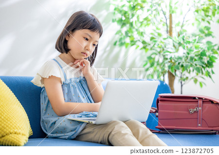Elementary school student using a computer in the living room 123872705