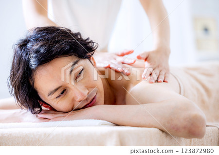 一名年輕男子在美容院接受按摩 123872980