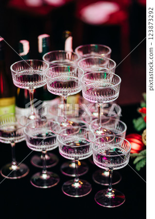 A pyramid of wide champagne glasses on deep blue tablecloth at event A pyramid of wide champagne glasses on deep blue tablecloth at event 123873292