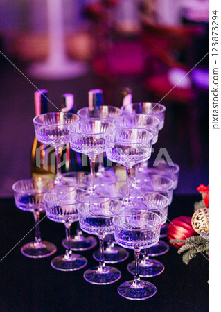 A pyramid of wide champagne glasses on deep blue tablecloth at event A pyramid of wide champagne glasses on deep blue tablecloth at event 123873294