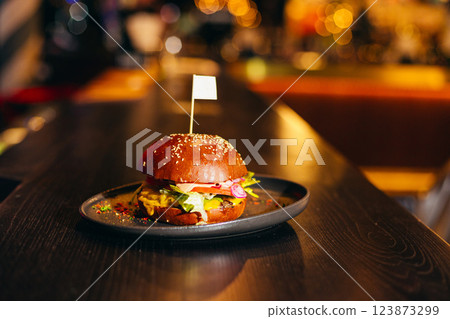 A hamburger with a flag on top of it, in pub on counter 123873299
