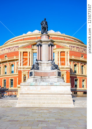 The Memorial to the Great Exhibition honors Albert, Prince Consort. Located south of Royal Albert Hall, this outdoor monument captures architectural beauty against a clear blue sky. 123873587