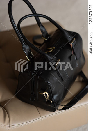 Black leather travel bag on a chair 123873702