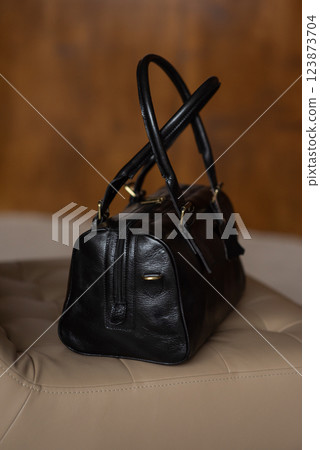 Black leather travel bag on a chair Black leather travel bag on a chair 123873704