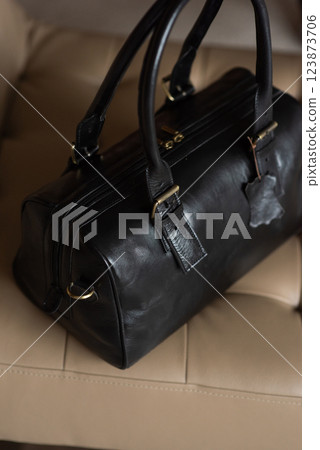 Black leather travel bag on a chair 123873706