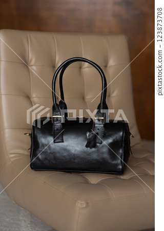 Black leather travel bag on a chair 123873708