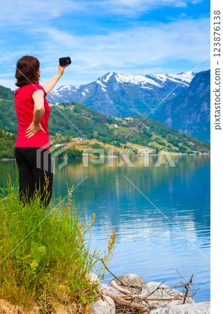 Tourist taking photo at norwegian fjord Tourist taking photo at norwegian fjord 123876138