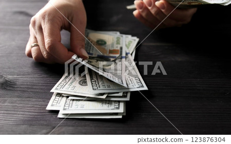 Woman Counting Her Cash Savings In Usa Dollar Bills 123876304