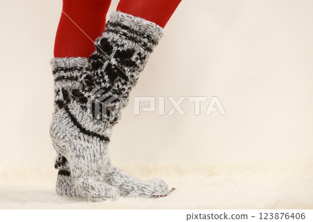 Woman legs wearing woolen socks and red tights 123876406