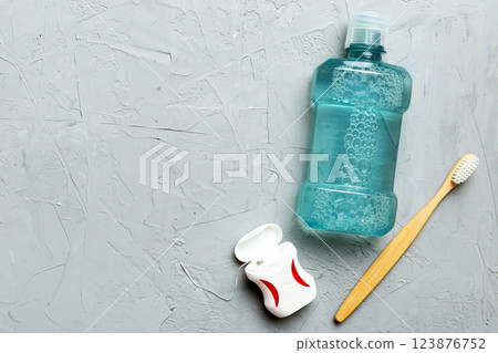 Mouthwash and other oral hygiene products on colored table top view with copy space. Flat lay. Dental hygiene. Oral care products and space for text on light background. concept Mouthwash and other oral hygiene products on colored table top view with copy space. Flat lay. Dental hygiene. Oral care products and space for text on light background. concept 123876752