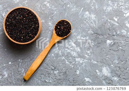 quinoa seeds in bowl and spoon on colored background. Healthy kinwa in small bowl. Healthy superfood quinoa seeds in bowl and spoon on colored background. Healthy kinwa in small bowl. Healthy superfood 123876769