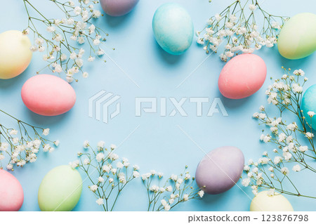 Happy Easter composition. Easter eggs on colored table with gypsophila. Natural dyed colorful eggs background top view with copy space 123876798