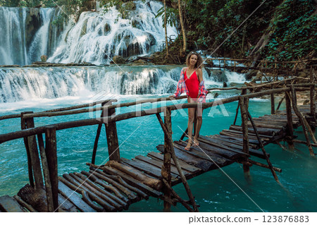 Traveller woman on bridge at cascade waterfalls with turquoise water in Central Sulawesi 123876883