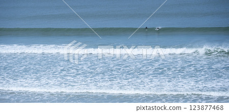 Surfing at Biscarrosse Beach as Waves Roll Gently Under a Clear Sky Surfing at Biscarrosse Beach as Waves Roll Gently Under a Clear Sky 123877468