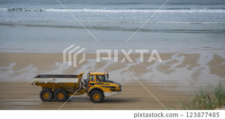 Heavy machinery transports sand along the biscarosse dune coastline, addressing coastal erosion 123877485