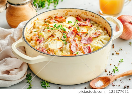 Delicious baked cabbage casserole with bacon prepared in a cream sauce on a kitchen table Delicious baked cabbage casserole with bacon prepared in a cream sauce on a kitchen table 123877621