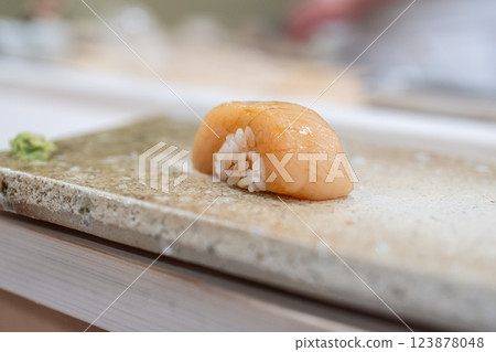 Scallop sushi elegantly presented on a handcrafted stone plate 123878048