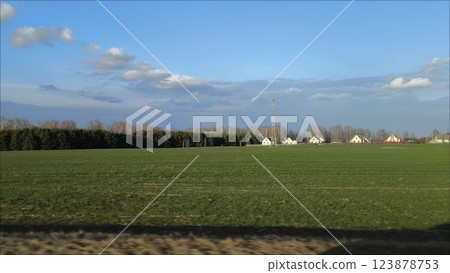 The view from the car window, the car rushing through the countryside. Spring landscape of peaceful rural life on a farm from the window of a speeding car. The view from the car window, the car rushing through the countryside. Spring landscape of peaceful rural life on a farm from the window of a speeding car. 123878753
