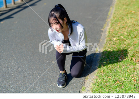 Young woman hurting her knee while jogging Danger Problem Diet Walking Walk 123878942