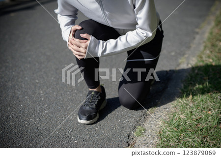 Young woman hurting her knee while jogging Danger Problem Diet Walking Walking Loss of color 123879069