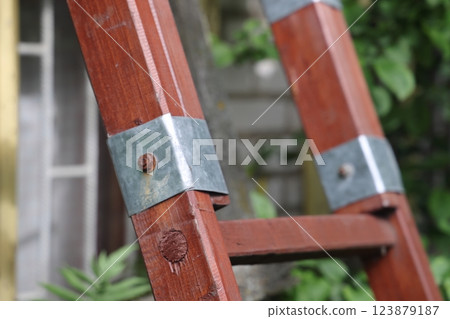 Old homemade wooden ladder leaning against an old shed made of wood and mud. Old homemade wooden ladder leaning against an old shed made of wood and mud. 123879187