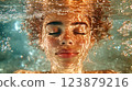 Close-up of a freckled woman submerged underwater with sunlight reflections. Creative underwater portrait. Water and serenity concept 123879216