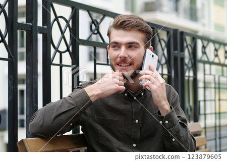 Young businessman talks on smartphone Young businessman talks on smartphone 123879605