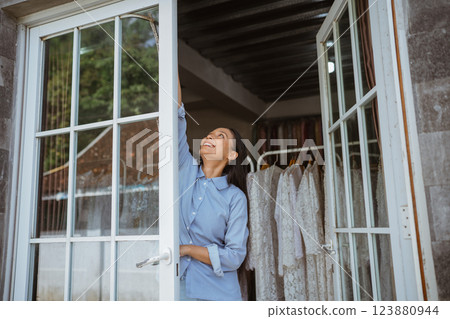 Contemplative Moment: Woman Reaching for the Sky in a Beautiful Closet 123880944