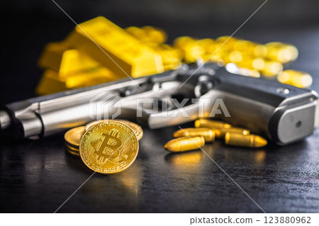 Bitcoin and gun. Gold coin cryptocurrency and gold bars on black table. 123880962